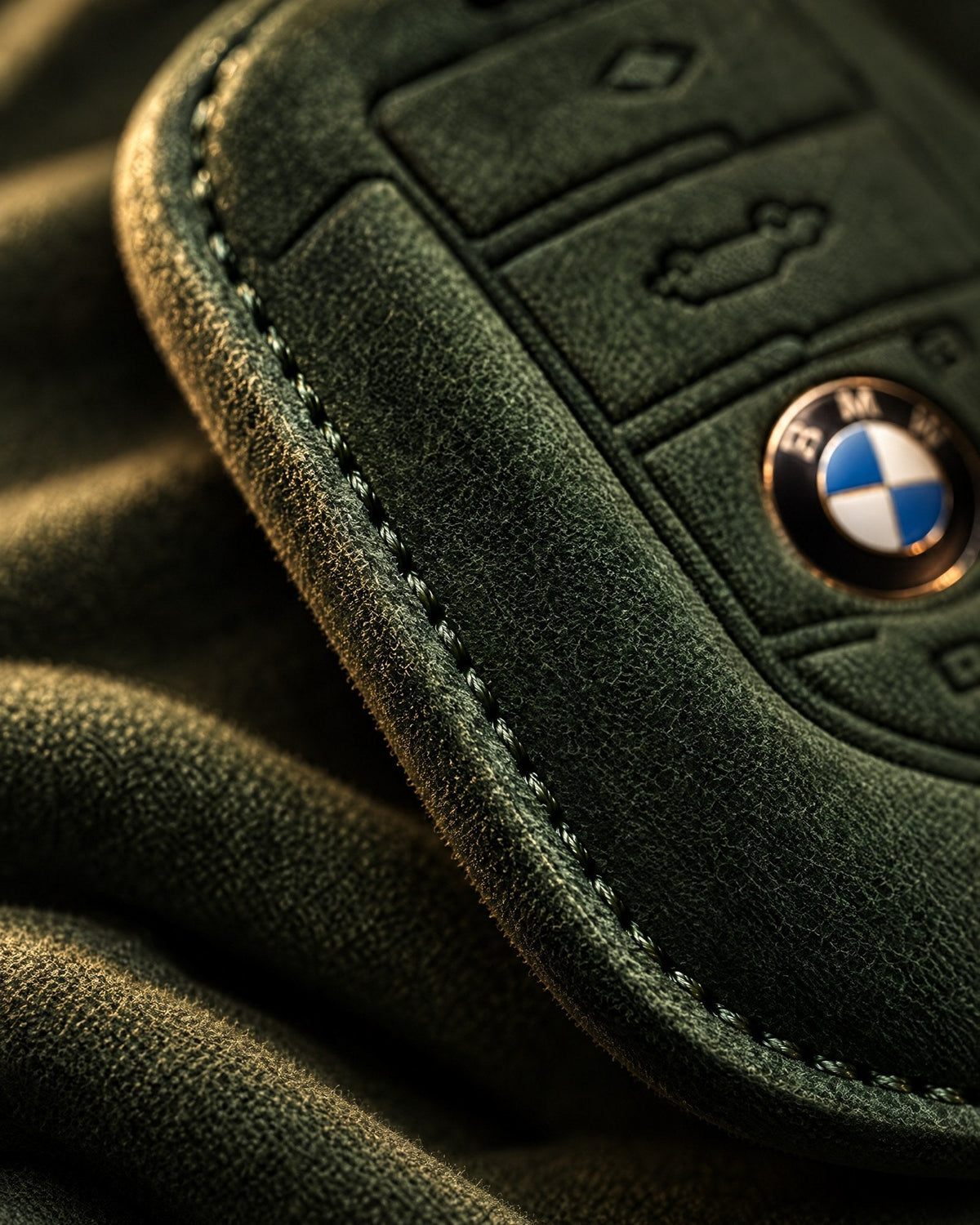 Close-up of the stitched edge on an olive green suede key cover